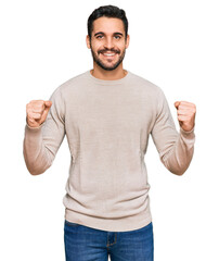 Fototapeta premium Young hispanic man wearing casual clothes celebrating surprised and amazed for success with arms raised and open eyes. winner concept.
