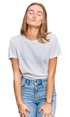 Obraz premium Beautiful young blonde woman wearing casual white t shirt looking at the camera blowing a kiss on air being lovely and sexy. love expression.