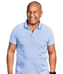 Hispanic middle age man wearing casual t shirt winking looking at the camera with sexy expression, cheerful and happy face.