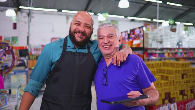 Two employees of Grocery store posing for camera, Brazilian workforce of supermarket, senior manager with staff