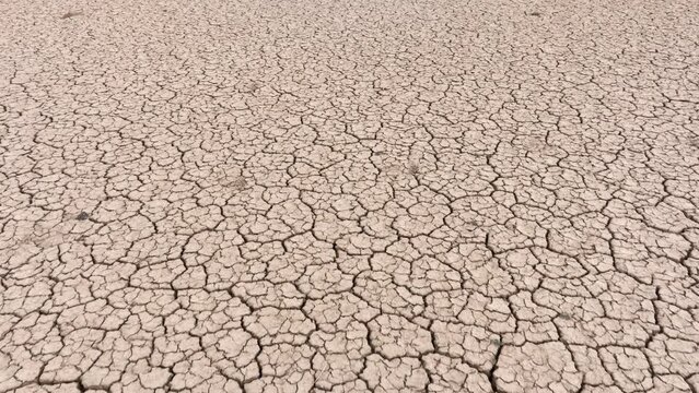 Aerial shot looking down at the cracked surface of a dry lake in Navada