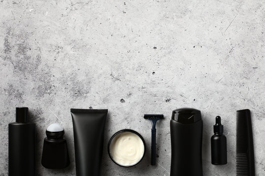 Premium men's grooming products, beauty and personal care concept. Flat lay black shampoo bottle, shower gel tube, deodorant, moisturizer cream, razor, serum, hair comb.