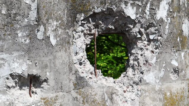 Video of a broken cement wall. Stone grunge odd wall with a hole. Hole in the wall, damaged surface, concrete fence. Holes after the punch.