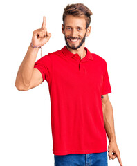 Handsome blond man with beard wearing casual clothes pointing finger up with successful idea. exited and happy. number one.