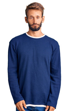 Handsome blond man with beard wearing casual sweater depressed and worry for distress, crying angry and afraid. sad expression.