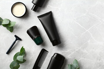 Premium men's SPA cosmetics set with green plants on stone table. Bath beauty products in black...