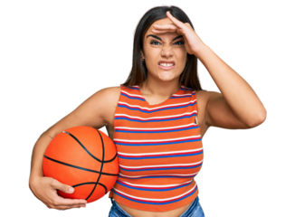 Young brunette woman holding basketball ball stressed and frustrated with hand on head, surprised and angry face