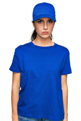 Young hispanic girl wearing delivery courier uniform depressed and worry for distress, crying angry and afraid. sad expression.