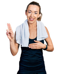 Young caucasian woman wearing sportswear and towel smiling swearing with hand on chest and fingers...