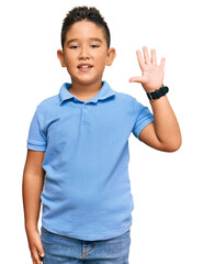 Little boy hispanic kid wearing casual clothes showing and pointing up with fingers number five while smiling confident and happy.