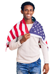 African handsome man holding united states flag looking positive and happy standing and smiling with a confident smile showing teeth