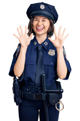 Young beautiful girl wearing police uniform showing and pointing up with fingers number ten while smiling confident and happy.