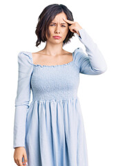 Young beautiful girl wearing casual clothes pointing unhappy to pimple on forehead, ugly infection of blackhead. acne and skin problem