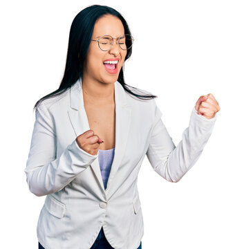 Beautiful hispanic woman with nose piercing wearing business jacket and glasses excited for success with arms raised and eyes closed celebrating victory smiling. winner concept.