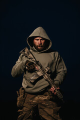 Ukrainian Soldier with his rifle wearing hoody on a black background