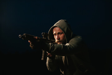 Fototapeta premium Armed Ukrainian military man aiming his rifle at night