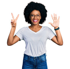 Young african american woman wearing casual white t shirt showing and pointing up with fingers number seven while smiling confident and happy.