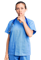 Young beautiful blonde woman wearing doctor uniform and stethoscope asking to be quiet with finger on lips. silence and secret concept.