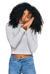 Young african american girl wearing casual clothes sleeping tired dreaming and posing with hands together while smiling with closed eyes.