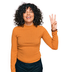 Young hispanic woman wearing casual clothes showing and pointing up with fingers number three while smiling confident and happy.