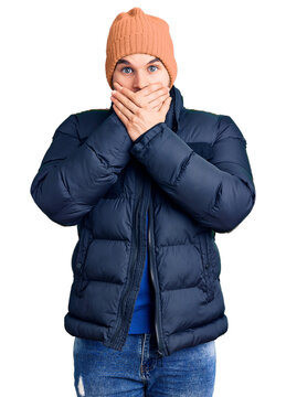 Young handsome man wearing winter clothes shocked covering mouth with hands for mistake. secret concept.