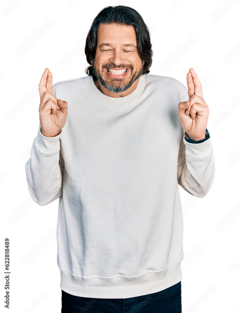 Sticker Middle age caucasian man wearing casual clothes gesturing finger crossed smiling with hope and eyes closed. luck and superstitious concept.