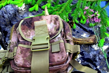 Equipment for outdoor travel on camouflage fabric with branches of coniferous trees