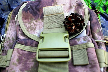 Equipment for outdoor travel on camouflage fabric with branches of coniferous trees