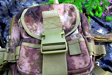 Equipment for outdoor travel on camouflage fabric with branches of coniferous trees