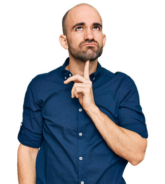 Young hispanic man wearing casual clothes thinking concentrated about doubt with finger on chin and looking up wondering
