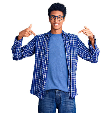 Young african american man wearing casual clothes and glasses looking confident with smile on face, pointing oneself with fingers proud and happy.
