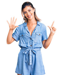 Young beautiful woman wearing casual clothes showing and pointing up with fingers number seven while smiling confident and happy.