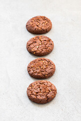 Chocolate cookies with oatmeal, chocolate chips and hazelnuts. Light grey background. Close up