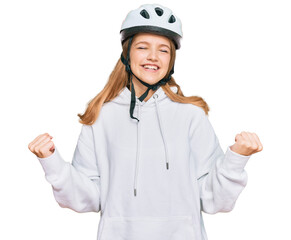 Beautiful young caucasian girl wearing bike helmet very happy and excited doing winner gesture with arms raised, smiling and screaming for success. celebration concept.