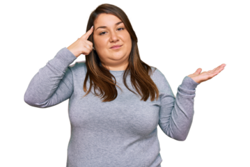 Beautiful brunette plus size woman wearing casual clothes confused and annoyed with open palm showing copy space and pointing finger to forehead. think about it.