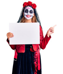 Woman wearing day of the dead costume holding blank empty banner smiling happy pointing with hand and finger to the side