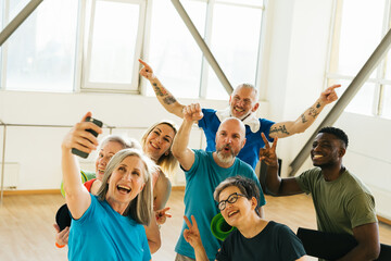 Pensioners athletes taking selfies on smartphone in gym