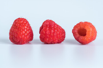 Three raspberries on a white background, closeup.