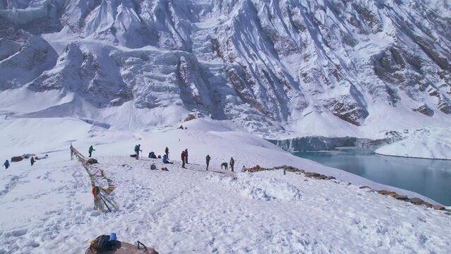 Aerial close up circular view group of trekkers by famous Tilicho lake trek viewpoint destination. Nepal popular treks. Manang. Himalayas mountains trekking concept