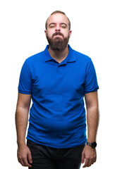 Young caucasian hipster man wearing blue shirt over isolated background puffing cheeks with funny face. Mouth inflated with air, crazy expression. - obrazy, fototapety, plakaty