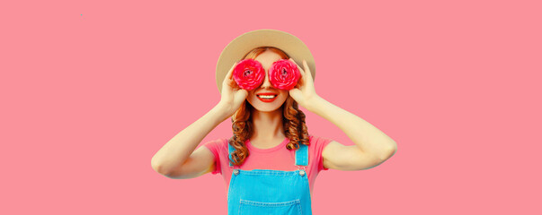 Summer portrait of happy smiling young woman covering her eyes with flower buds as binoculars...