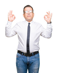 Middle age bussines arab man wearing glasses over isolated background relax and smiling with eyes closed doing meditation gesture with fingers. Yoga concept.