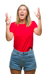Young beautiful woman over isolated background crazy and mad shouting and yelling with aggressive expression and arms raised. Frustration concept.