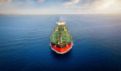 Aerial front view of a heavy crude oil tanker traveling over calm sea during sunset