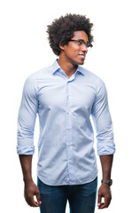 Afro american business man wearing glasses over isolated background looking away to side with smile on face, natural expression. Laughing confident.