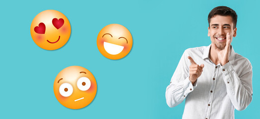 Young gossiping man pointing at different emoticons on blue background