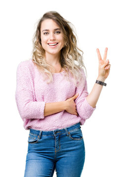 Beautiful young blonde woman over isolated background smiling with happy face winking at the camera doing victory sign. Number two.