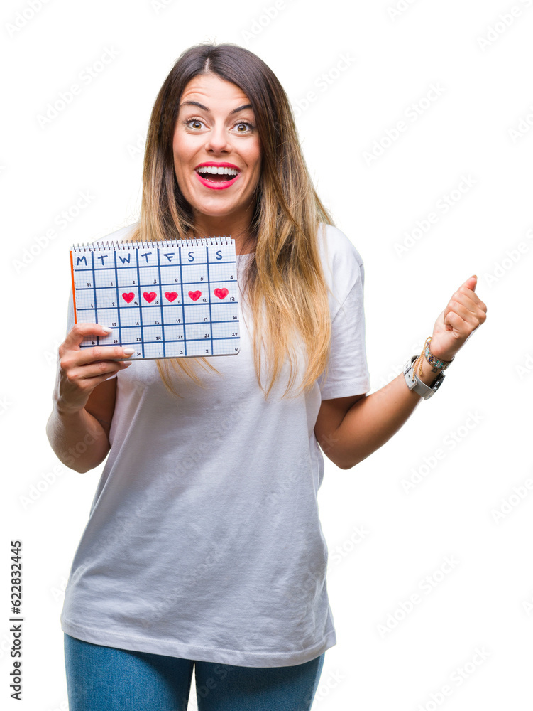 Poster Young beautiful woman holding menstruation calendar over isolated background screaming proud and celebrating victory and success very excited, cheering emotion