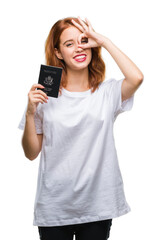 Fototapeta premium Young beautiful woman holding passport of united states of america over isolated background with happy face smiling doing ok sign with hand on eye looking through fingers