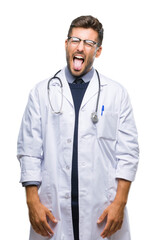 Young handsome doctor man over isolated background sticking tongue out happy with funny expression. Emotion concept.